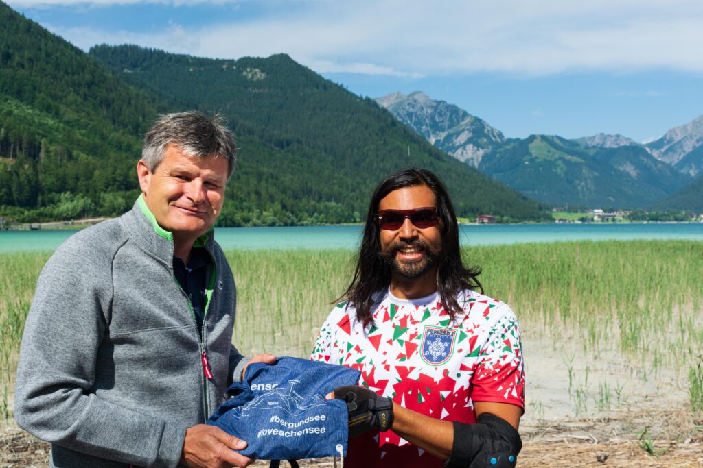 Geschäftsführer Martin Tschoner (li.) überreichte jedem Athleten ein Begrüßungsgeschenk von Achensee Tourismus – so auch dem in Tirol lebenden Mexikaner Raul Antonio Figueroa. ©Achensee Tourismus