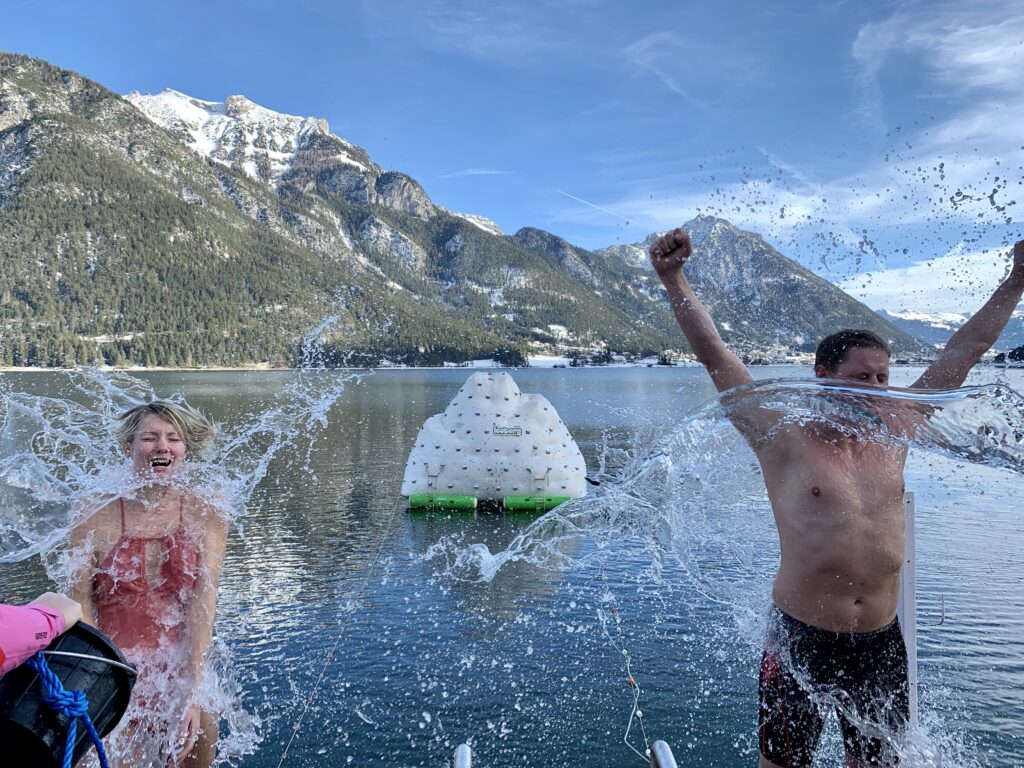 Um für den Sprung in den eiskalten Achensee gewappnet zu sein, gießen die Black Divers Tirol, die das Silvesterschwimmen veranstalten, den Schwimmern einen Kübel Wasser über den Kopf.