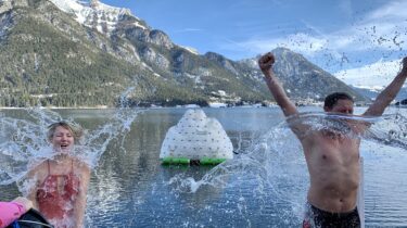 Um für den Sprung in den eiskalten Achensee gewappnet zu sein, gießen die Black Divers Tirol, die das Silvesterschwimmen veranstalten, den Schwimmern einen Kübel Wasser über den Kopf.