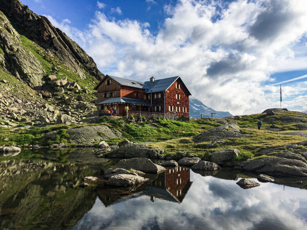 Die Bremer Hütte auf dem sonnigen Hochplateau am Rand eines kleinen Bergsees – eine der längsten Etappe des Gschnitztaler Hüttensterns.