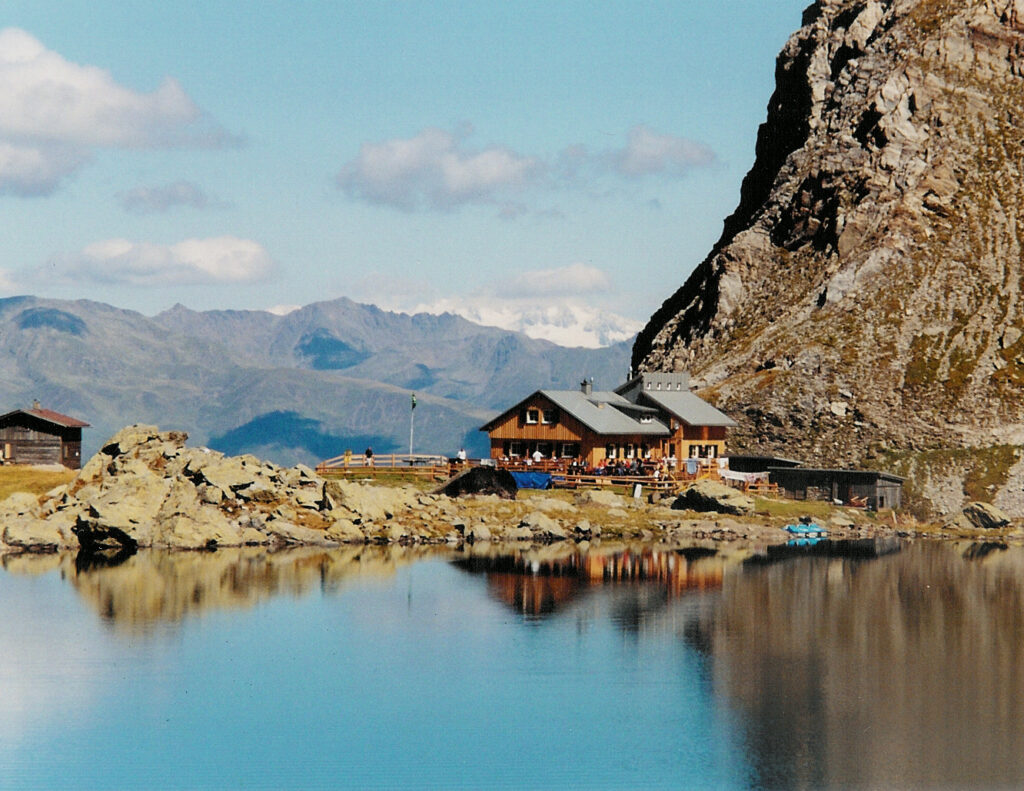 Ein Anblick, der für jeden Aufstieg belohnt: Der tiefblaue Obstanser See im Osttiroler Teil der Karnischen Alpen mit der gleichnamigen Hütte.