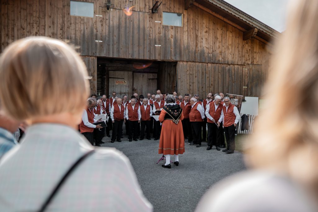 Gesangsgruppen schaffen beim Chöretreffen „Wenn i durchgeh durchs Tal“ ein musikalisches Erlebnis– begleitet von regionalen Schmankerln und umgeben von beeindruckender Bergkulisse.