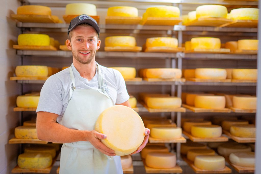 Thomas Almberger von der Steiner Alm präsentiert seinen prämierten Almkäse – ausgezeichnet mit Gold für Graukäse und Silber für Zirbenkäse bei der Internationalen Almkäseolympiade 2024 in Galtür.