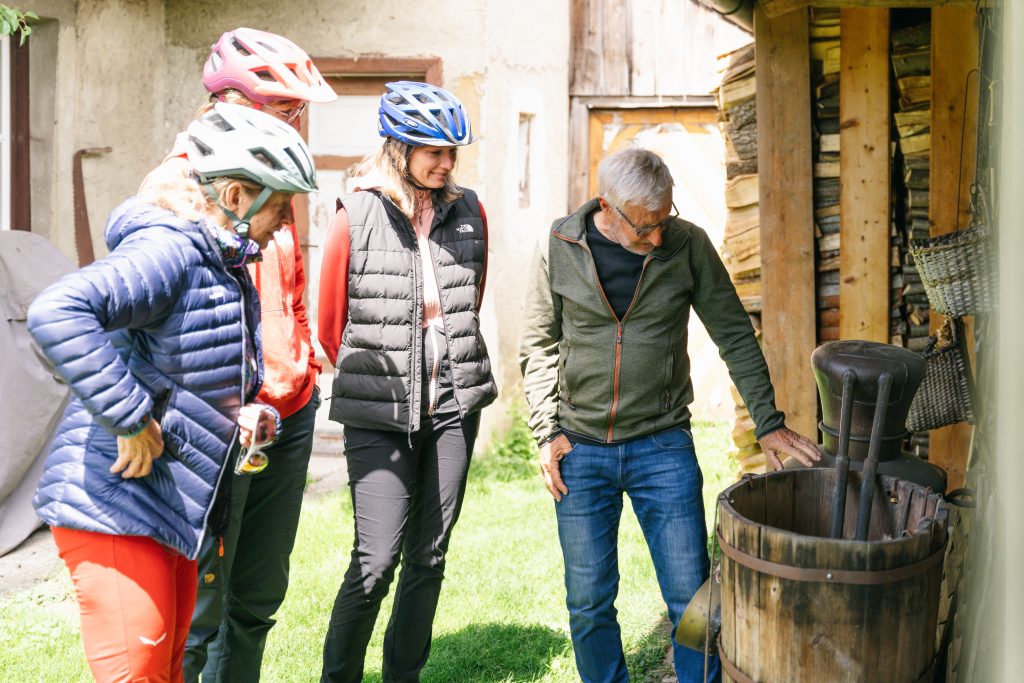 Eine Gruppe Touristen bekommt von einem Einheimischen eine Einführung ins Schnapsbrennen.